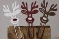 Dúo de clips decorativos navideños con diseño de renos.
