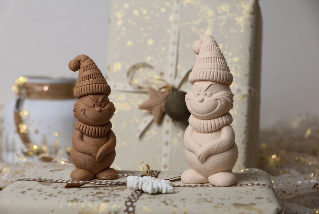 Figuras decorativas de Navidad impresas en 3D, con diseños de gnomos, magos y renos en tonos neutros.
