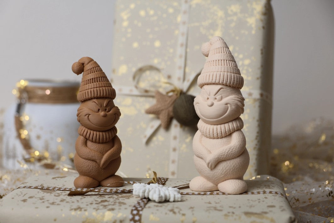 Figuras decorativas de Navidad impresas en 3D, con diseños de gnomos, magos y renos en tonos neutros.
